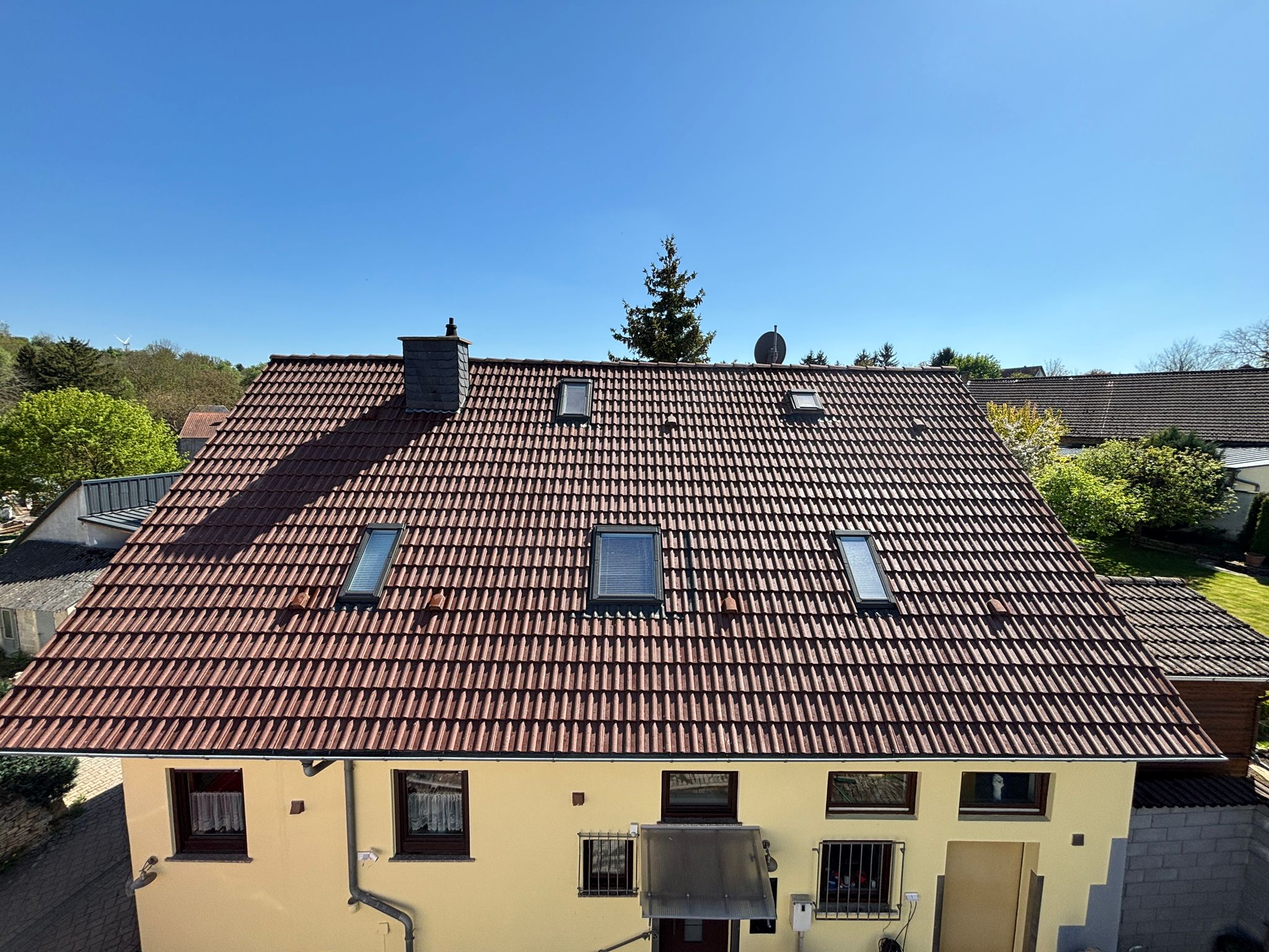 Doppelhaus mit Tonziegeln nach der Dachreinigung, kräftige Farbe wiederhergestellt