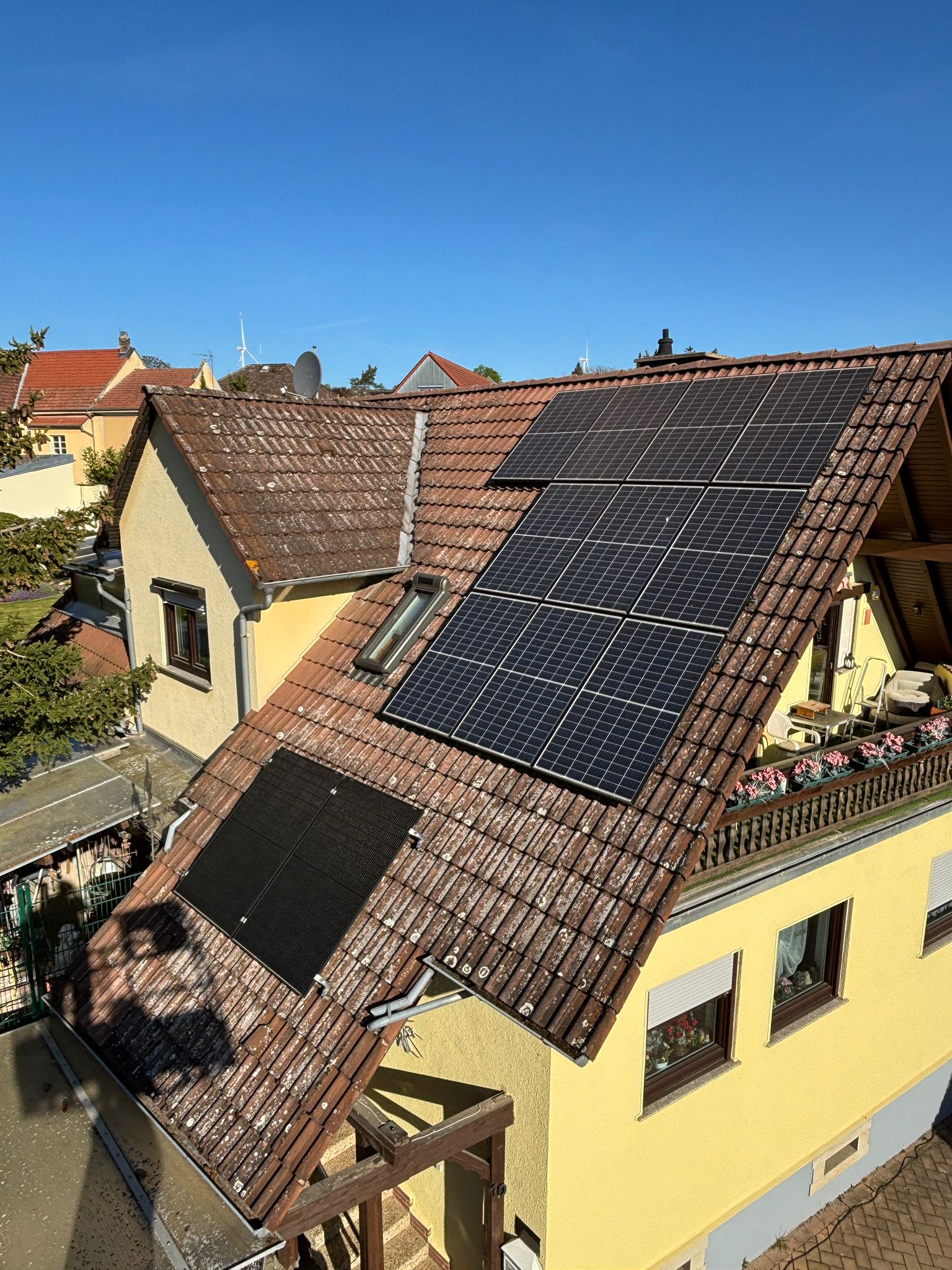 Einfamilienhaus mit PV-Anlage vor der Dachreinigung, Moosbefall zwischen den Modulen